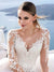Robe de mariée chic et classe avec bustier en dentelle brodée, décolleté illusion et manches longues transparentes, style élégant et raffiné avec détails floraux.