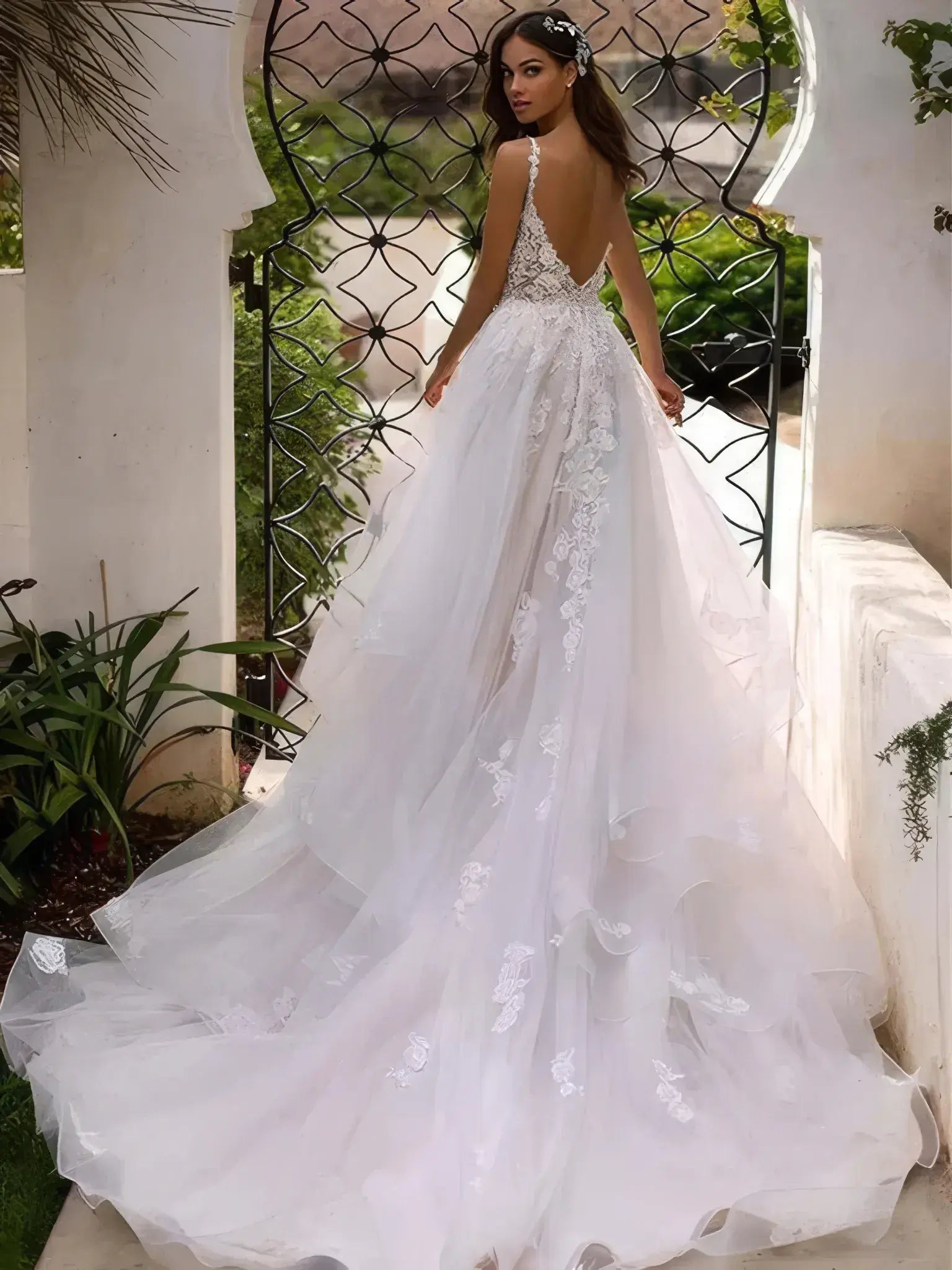 Dos ajouré et traîne volumineuse de la robe de mariée en dentelle fleurie