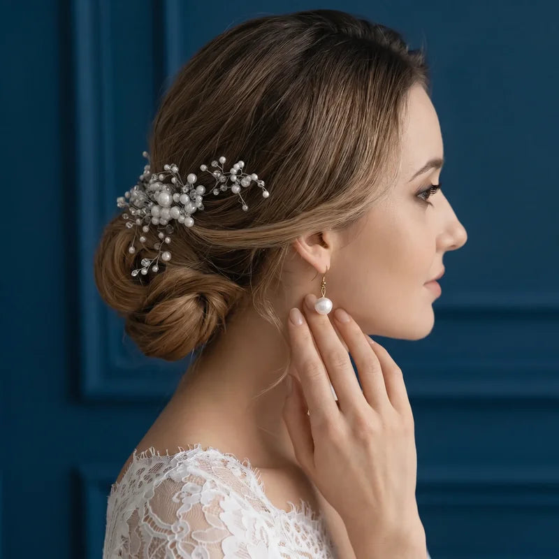 Chignon de mariée orné d'un bijou de cheveux et boucles en perles