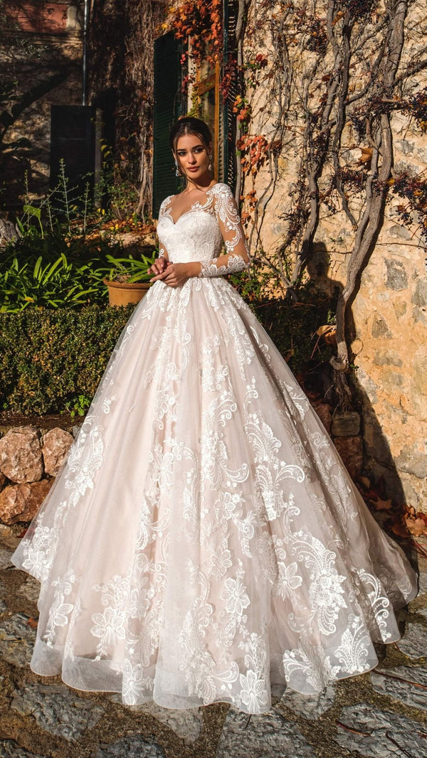 Robe de mariage princesse style royal, bustier cœur en dentelle, manches longues transparentes et jupe en tulle à appliqués floraux