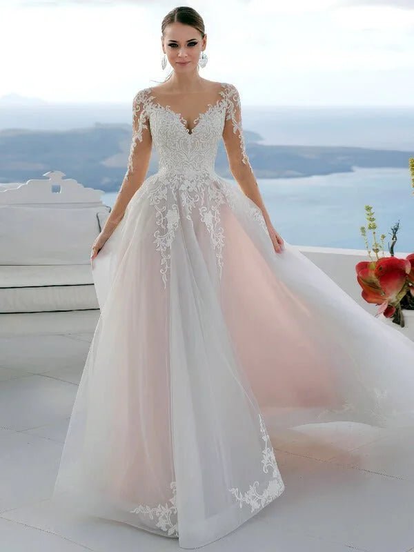 Robe de mariée chic et classe en tulle ivoire et dentelle délicate, coupe princesse avec manches longues et jupe fluide volumineuse, silhouette élégante et romantique.