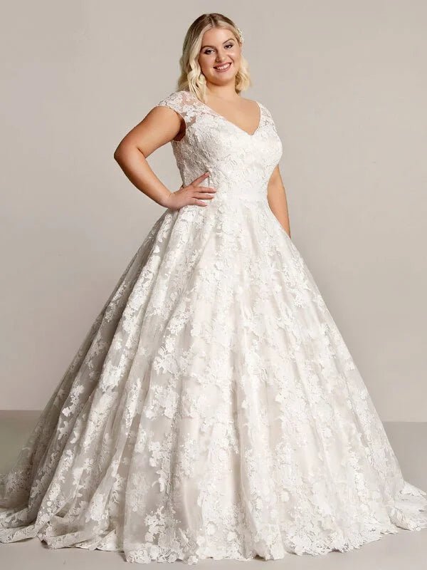 Robe de mariée romantique pour femme ronde en dentelle avec décolleté en V, manches courtes et jupe ample, silhouette élégante et féminine.