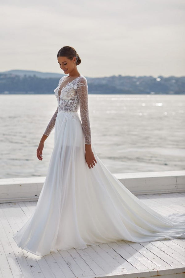 Robe de mariée bohème chic, manches longues pailletées, décolleté plongeant en dentelle florale, jupe fluide en mousseline