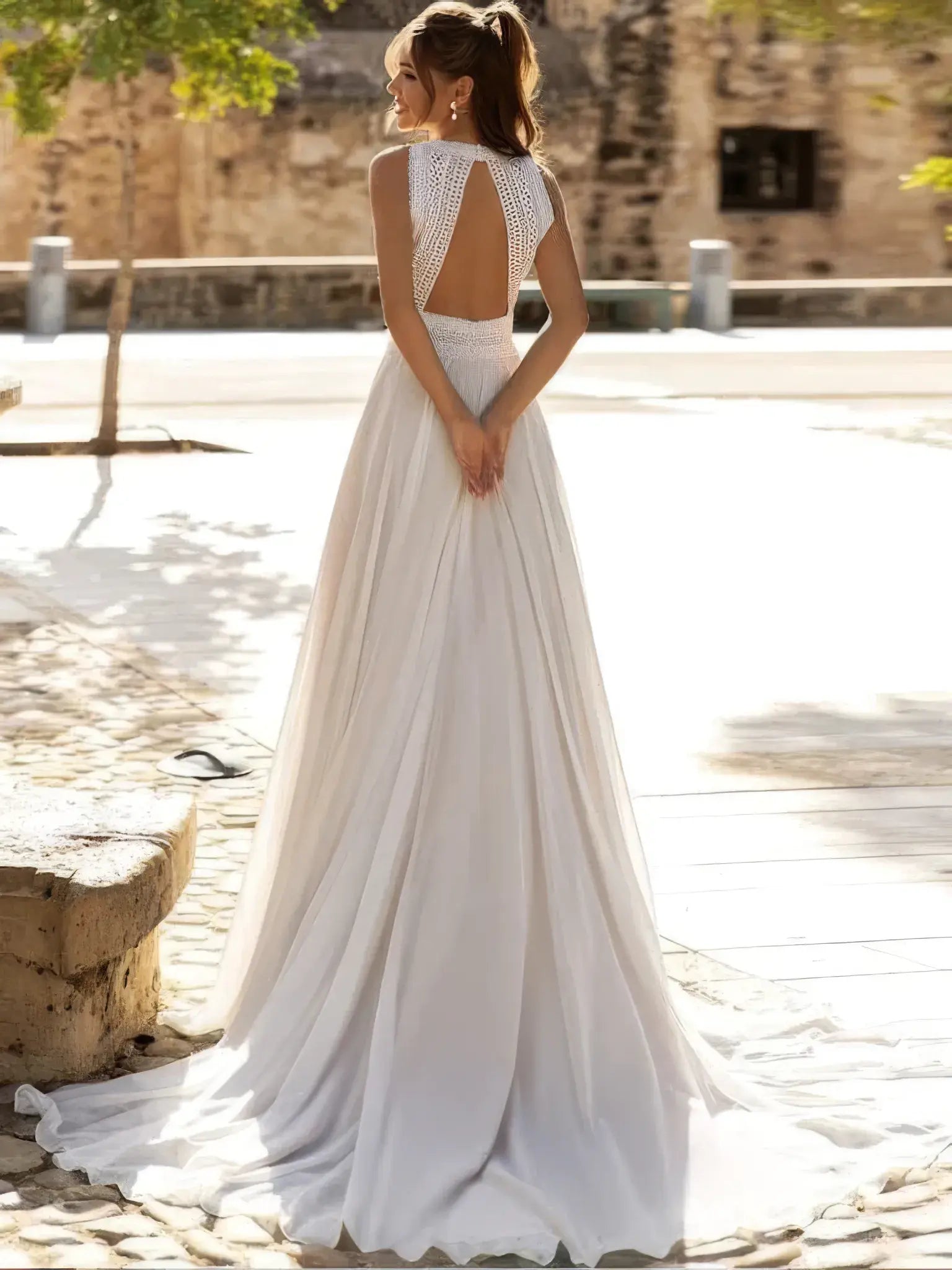 Robe de mariée champêtre à dos nu portée de face, jupe fluide et buste brodé