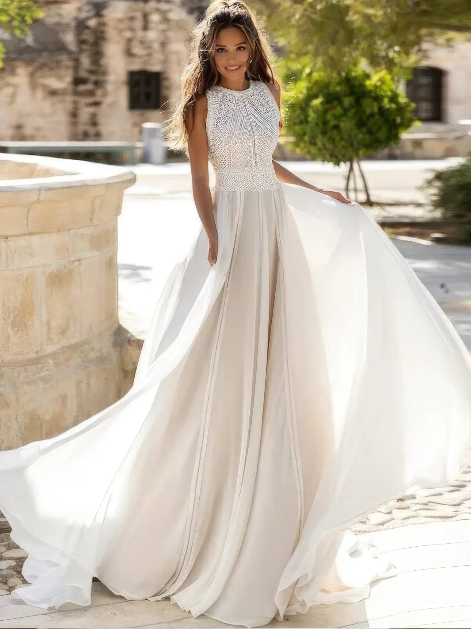 Robe de mariée champêtre à dos nu portée de face, jupe fluide et buste brodé